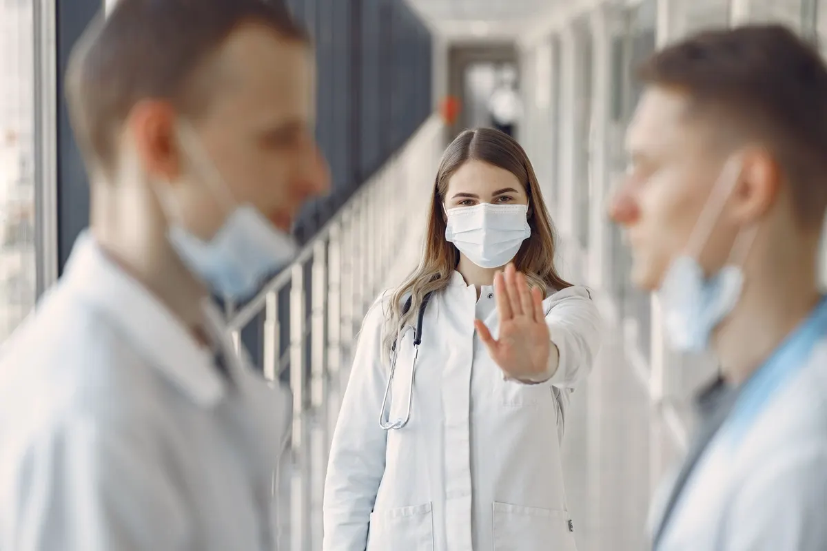 Doctors in masks demonstrating healthcare safety and teamwork indoors.